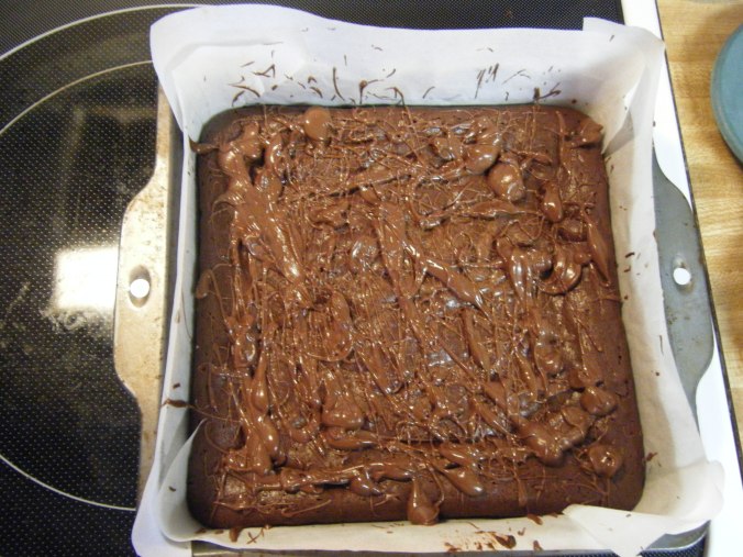After drizzling the ganache. For ease of transport, I left them in the pan, but the parchment paper makes it super easy to pull the whole brownie out to present on a plate.